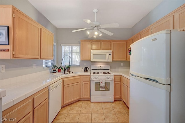 kitchen featuring white appliances, a ceiling fan, tile countertops, light brown cabinetry, and light tile patterned flooring