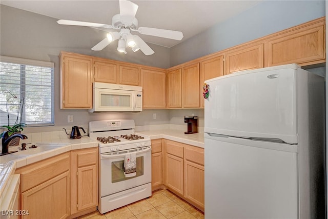 kitchen featuring white appliances, light tile patterned floors, a sink, and light brown cabinetry