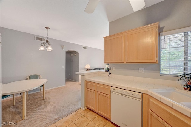 kitchen with light colored carpet, arched walkways, light brown cabinets, and white dishwasher