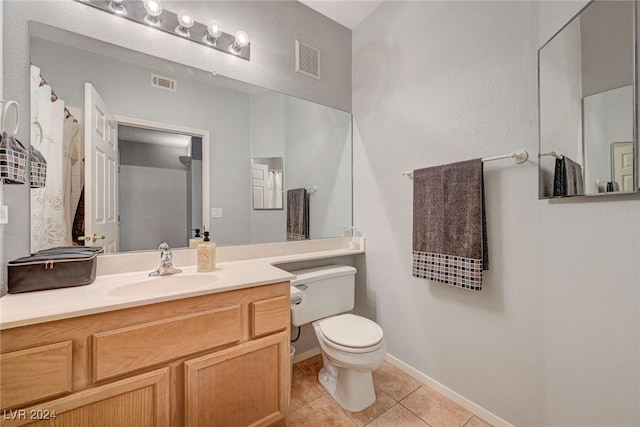 bathroom with toilet, vanity, visible vents, and tile patterned floors