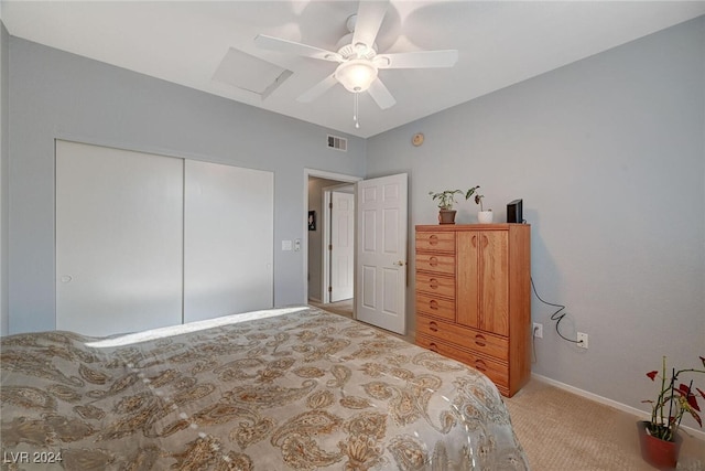 bedroom with ceiling fan, light colored carpet, visible vents, a closet, and attic access