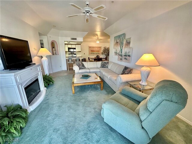 carpeted living room with lofted ceiling and ceiling fan