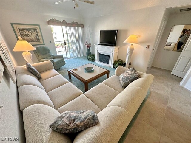 living room with a ceiling fan, visible vents, and a fireplace