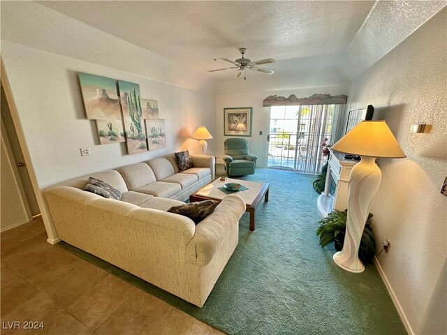 carpeted living area featuring a ceiling fan, a textured wall, a textured ceiling, and baseboards