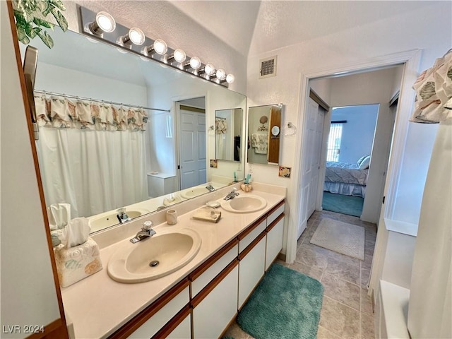 bathroom featuring visible vents, a sink, ensuite bath, and double vanity