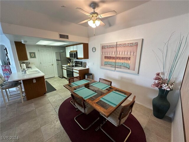 dining area featuring baseboards, visible vents, a ceiling fan, and light tile patterned flooring