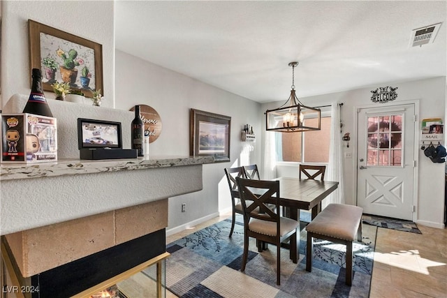 dining area with a chandelier and tile patterned floors