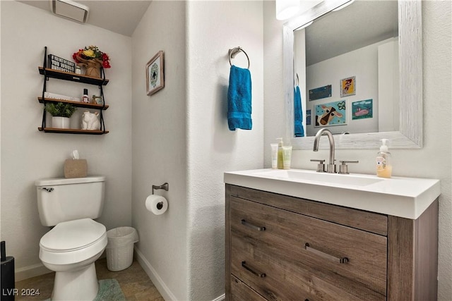 bathroom with tile patterned flooring, vanity, and toilet