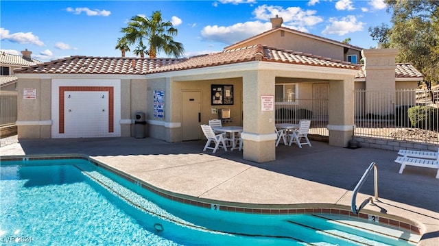 back of property with a patio area and a community pool