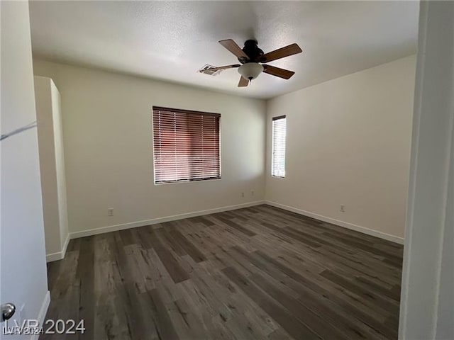 spare room with ceiling fan and dark wood-type flooring