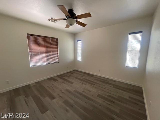 spare room with ceiling fan and dark wood-type flooring