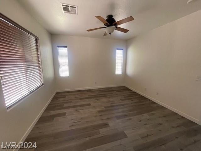 unfurnished room with dark hardwood / wood-style floors and ceiling fan