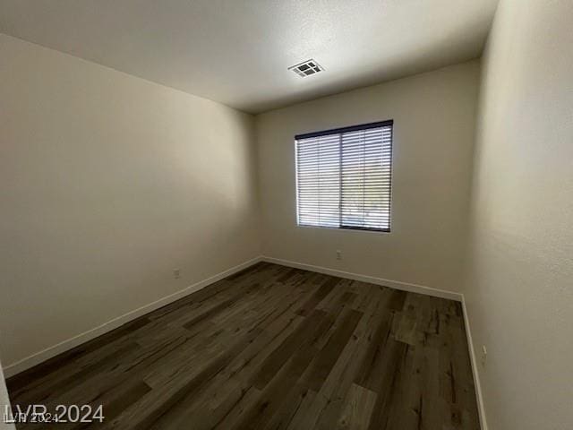 unfurnished room with dark wood-type flooring