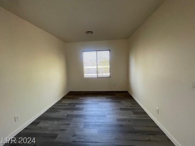 unfurnished room with dark wood-type flooring