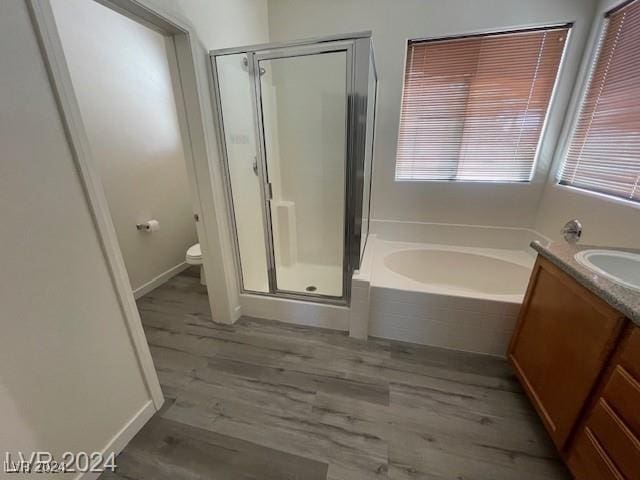 full bathroom with wood-type flooring, vanity, toilet, and independent shower and bath