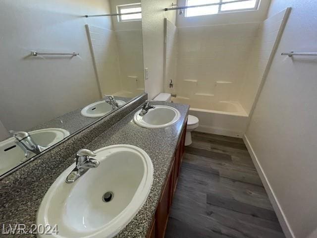 full bathroom featuring bathing tub / shower combination, plenty of natural light, hardwood / wood-style floors, and toilet