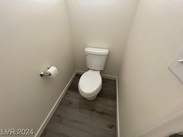 bathroom featuring toilet and wood-type flooring