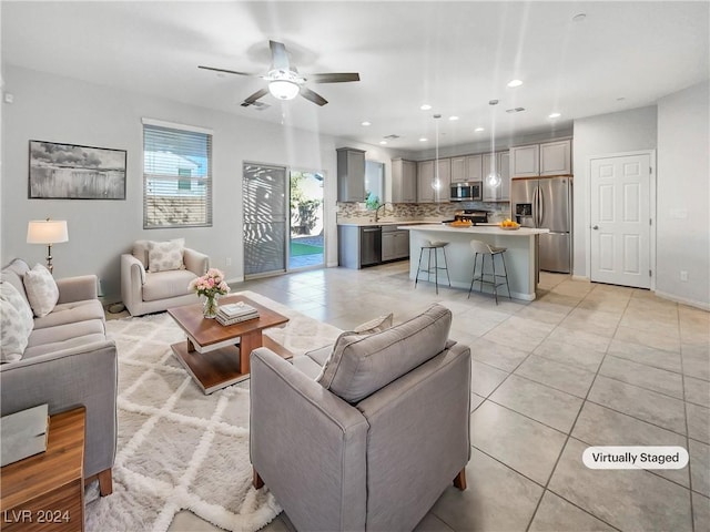 living room with ceiling fan, sink, and light tile patterned floors