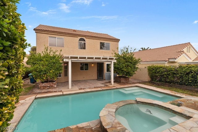 rear view of house featuring a pergola, a patio area, and a swimming pool with hot tub