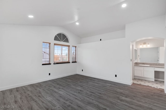 spare room with dark hardwood / wood-style flooring and lofted ceiling