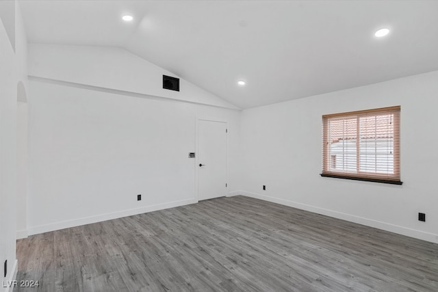 unfurnished room featuring hardwood / wood-style floors and lofted ceiling