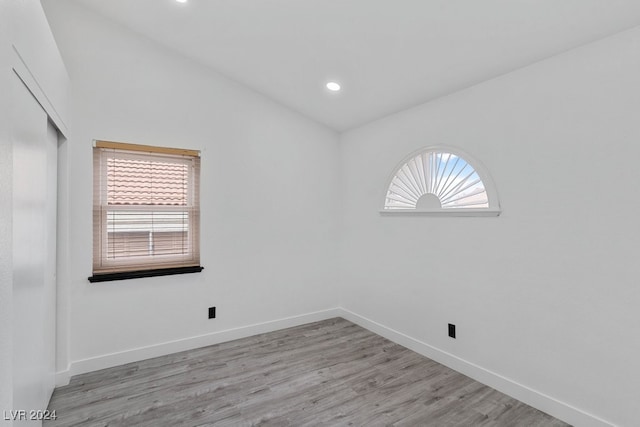 empty room featuring light hardwood / wood-style flooring and lofted ceiling