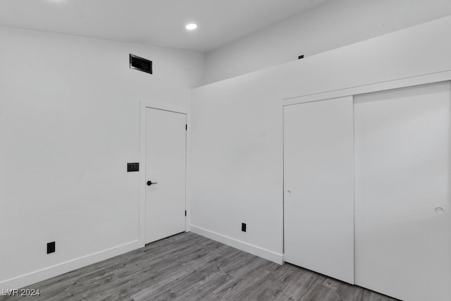 unfurnished bedroom with a closet and light wood-type flooring