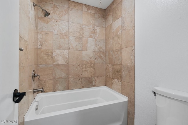 bathroom with tiled shower / bath combo and toilet