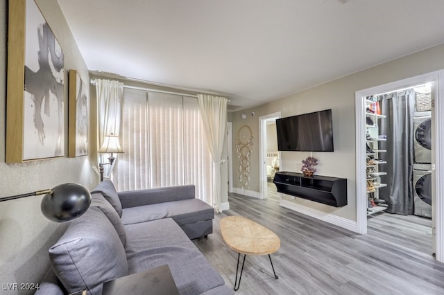 living room with stacked washer and dryer and light hardwood / wood-style flooring