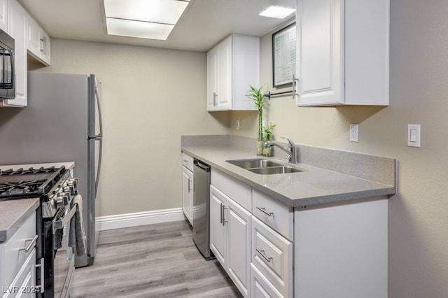 kitchen featuring white cabinets, sink, stainless steel appliances, and light hardwood / wood-style flooring