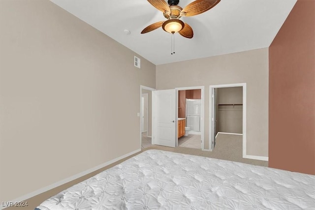 unfurnished bedroom with a walk in closet, ensuite bath, ceiling fan, light colored carpet, and a closet