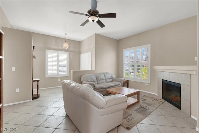 living room with a wealth of natural light, a fireplace, ceiling fan, and light tile patterned floors