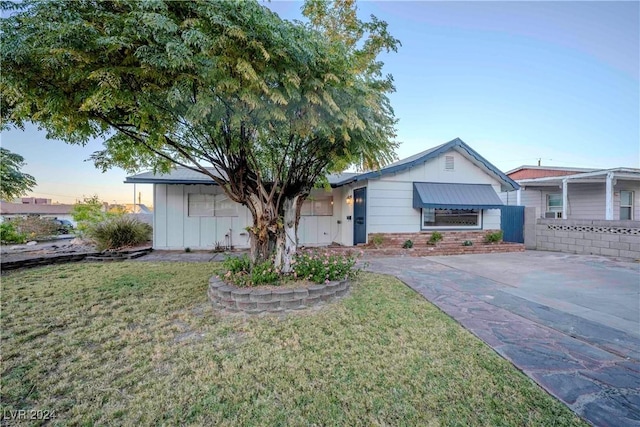 ranch-style home featuring a lawn