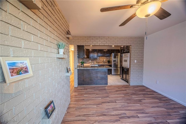 kitchen featuring dark brown cabinets, ceiling fan, light hardwood / wood-style flooring, stainless steel fridge with ice dispenser, and oven