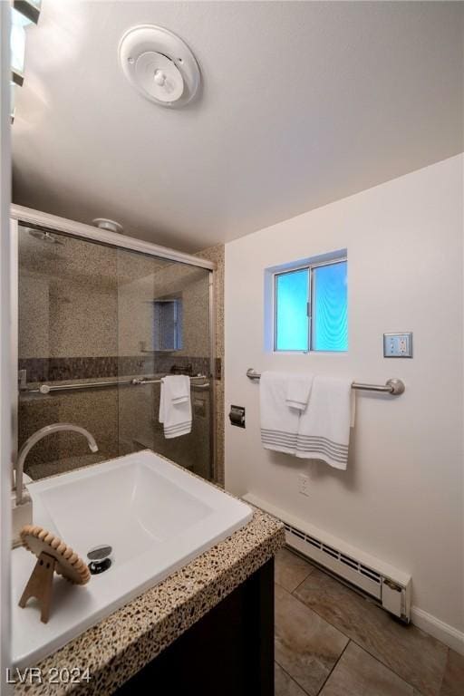 bathroom featuring vanity, a baseboard radiator, tile patterned floors, and a shower with shower door