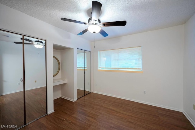 unfurnished bedroom with ceiling fan, dark hardwood / wood-style flooring, and a textured ceiling