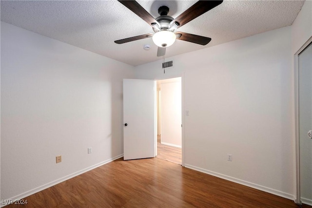 unfurnished bedroom featuring ceiling fan, wood-type flooring, and a textured ceiling