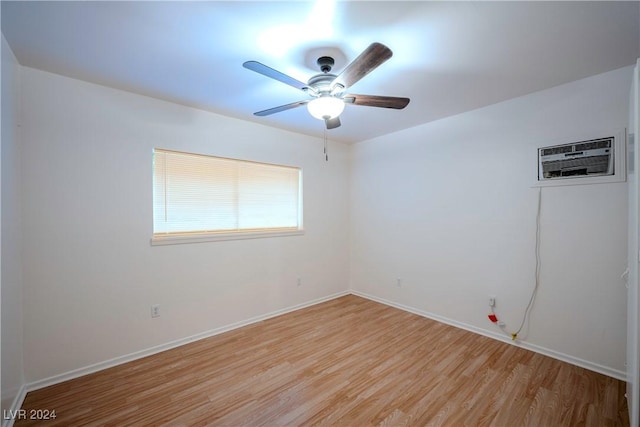 spare room featuring ceiling fan, light hardwood / wood-style floors, and a wall unit AC