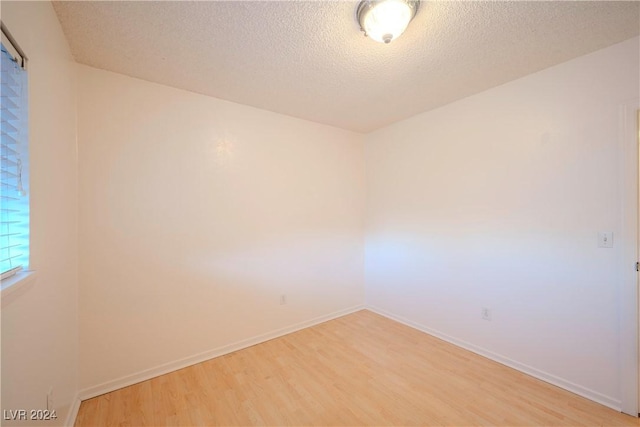 unfurnished room featuring hardwood / wood-style floors and a textured ceiling