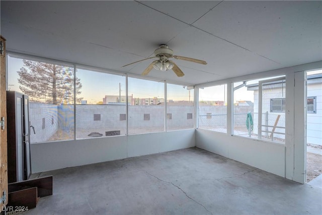 unfurnished sunroom with ceiling fan