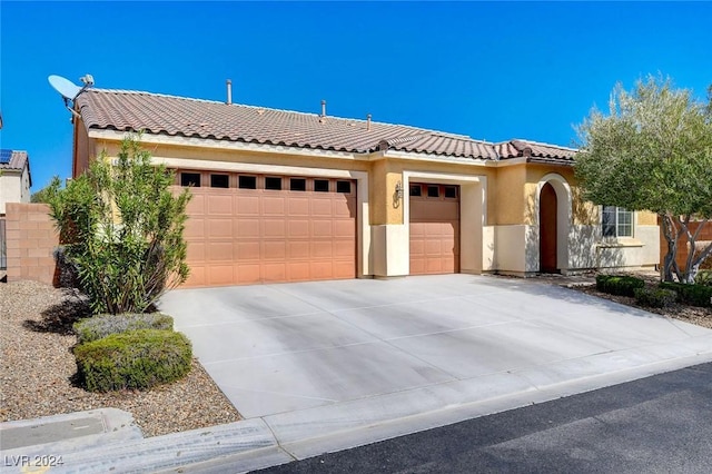 mediterranean / spanish home featuring a garage