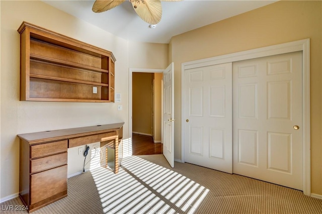 unfurnished office featuring light carpet and ceiling fan