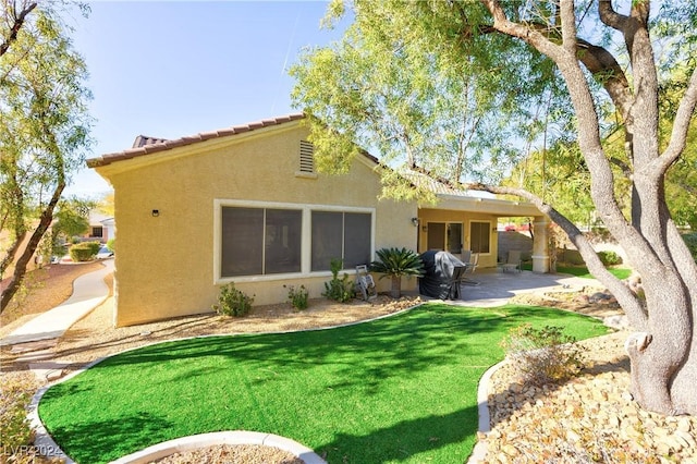 back of property featuring a yard and a patio area