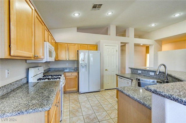 kitchen with sink, dark stone counters, lofted ceiling, white appliances, and light tile patterned floors