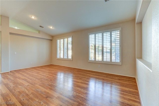 empty room featuring light hardwood / wood-style floors and vaulted ceiling