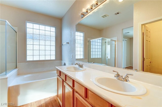 bathroom featuring hardwood / wood-style floors, vanity, and separate shower and tub