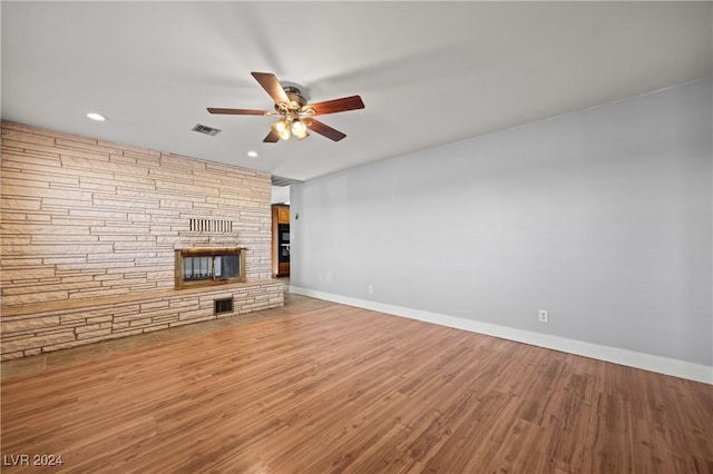 unfurnished living room with a fireplace, wood-type flooring, and ceiling fan