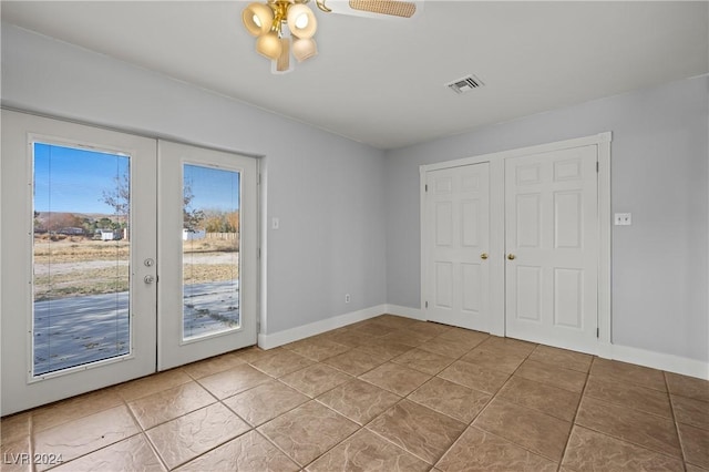 unfurnished bedroom featuring tile patterned floors, access to exterior, a closet, and french doors