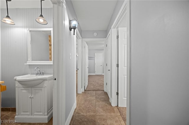 corridor with tile patterned floors and sink