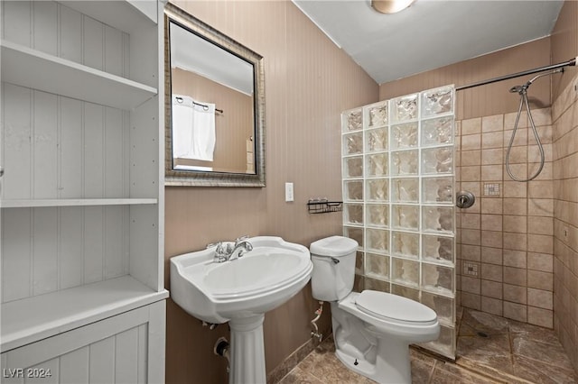 bathroom with tile patterned flooring, toilet, and tiled shower